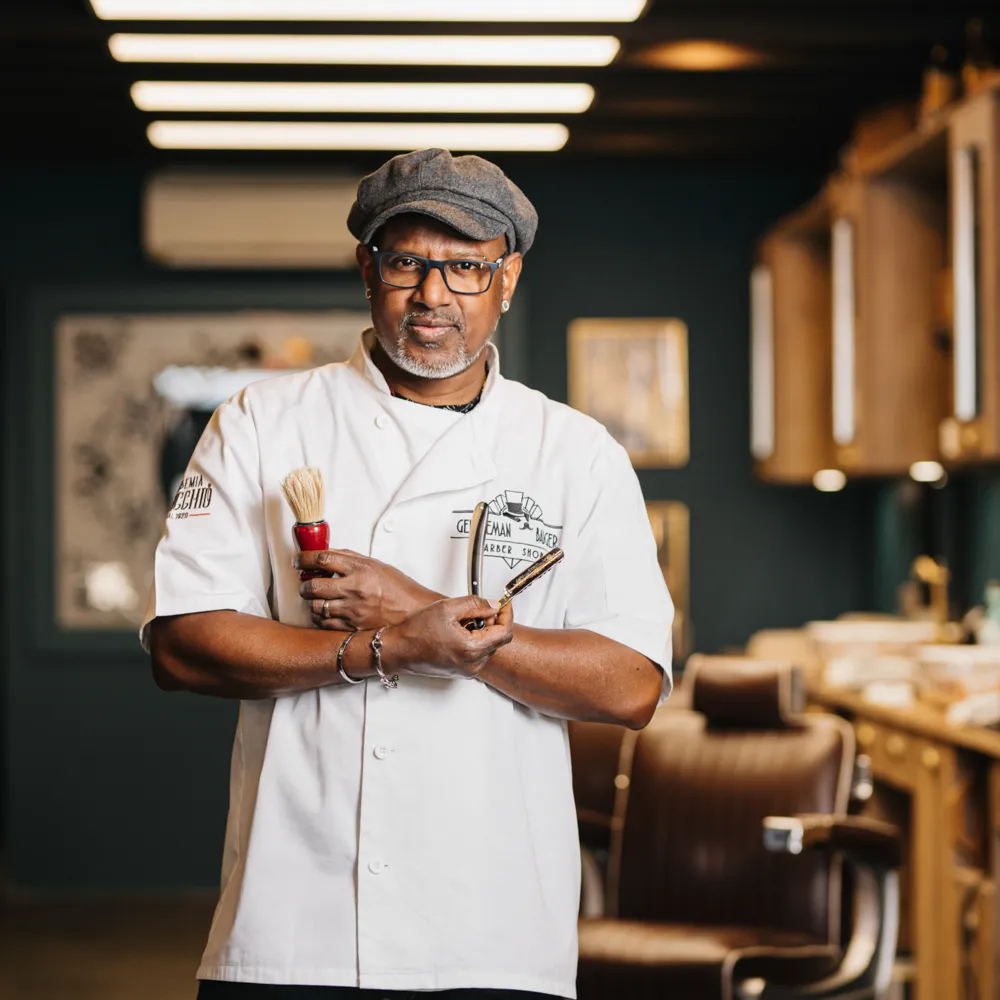 un barbier pose avec son rasoir et son blaireau à l'occasion d'un shooting photo d'entreprise à Draguignan